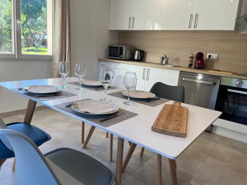 une cuisine avec une table avec des verres à vin dessus dans l'établissement Maison indépendante 2 Chambres jardin, à Saint-Aunès
