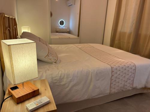 a bedroom with a bed and a table with a lamp at Maison indépendante 2 Chambres avec terrasse et jardin in Saint-Aunès