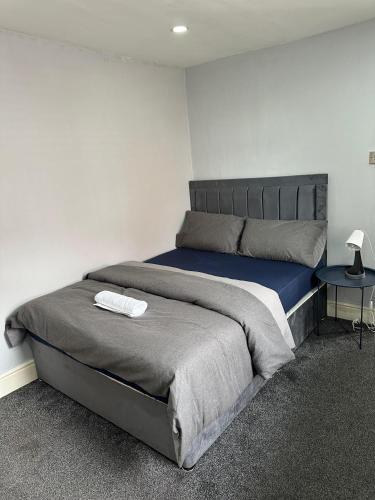 マンチェスターにあるBudget Room with Private Bathroomのベッドルーム1室(大型ベッド1台、サイドテーブル付)