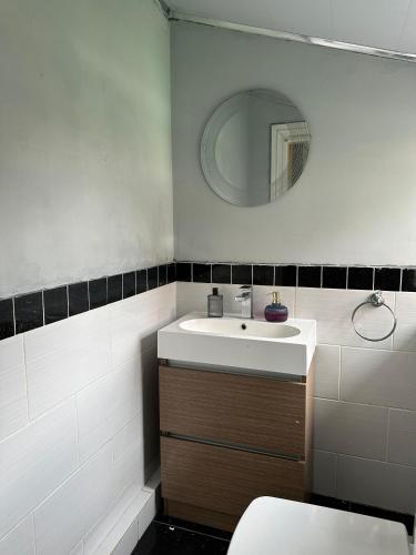 マンチェスターにあるBudget Room with Private Bathroomの洗面台と鏡のあるバスルーム