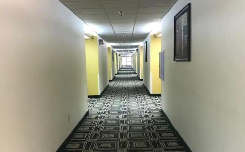 an empty hallway with yellow walls and a tile floor at Blue Way Inn Eagan Extended Stay in Eagan