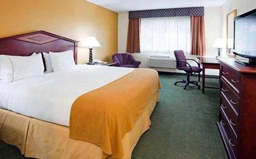 a hotel room with a large bed and a television at Blue Way Inn Eagan Extended Stay in Eagan