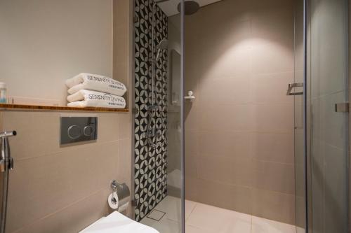 a shower with a glass door in a bathroom at Socio Tower1 - Dubai Hills Modern Urban Retreat in the City by Serenity Living Holiday Homes in Dubai