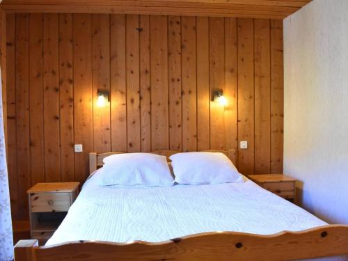una camera da letto con un letto con pareti e luci in legno di Chalet typique 8 personnes à Méribel, calme et pittoresque - FR-1-180-190 a Méribel