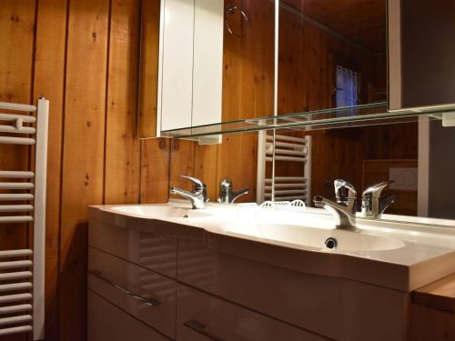 un bagno con due lavandini e uno specchio di Chalet typique 8 personnes à Méribel, calme et pittoresque - FR-1-180-190 a Méribel