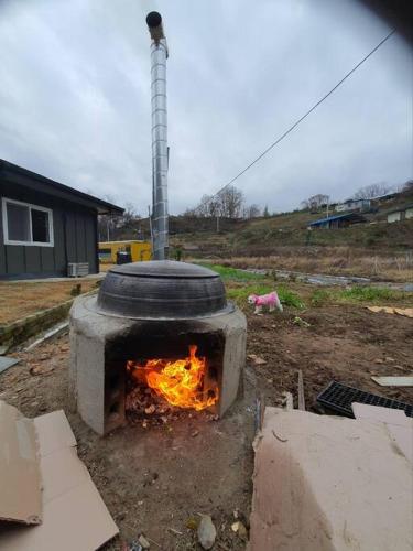 a fire oven with a tire on top of it at bokdakbokdak in Yeoncheon
