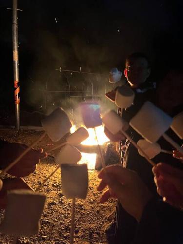 a group of people sitting around a fire at night at bokdakbokdak in Yeoncheon