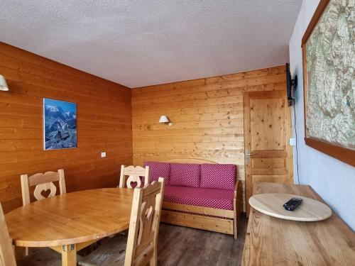 une salle à manger avec une table et un banc rose dans l'établissement Appartement pour 6 pers au pied des pistes avec balcon - Plagne Centre - FR-1-351-61, à La Plagne