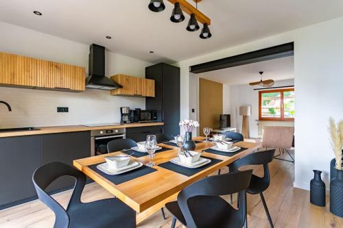une cuisine et une salle à manger avec une table et des chaises en bois dans l'établissement Superbe appartement, terrasse et parking privatif, à Schiltigheim