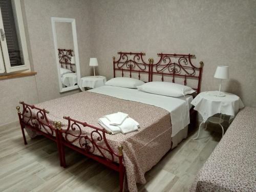 a bedroom with a large bed and two tables at La Buonanotte in Mantova