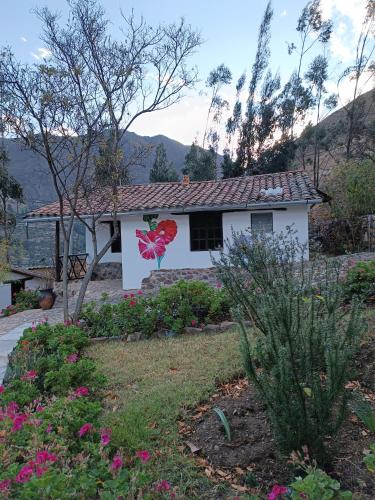 a white house with a flower painted on it at Tika bungalows hotel in Ollantaytambo