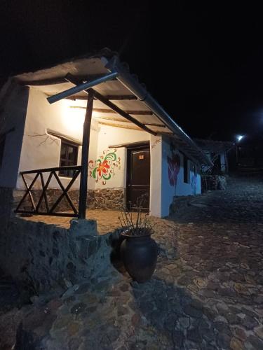 a small building with a pot in front of it at night at Tika bungalows hotel in Ollantaytambo