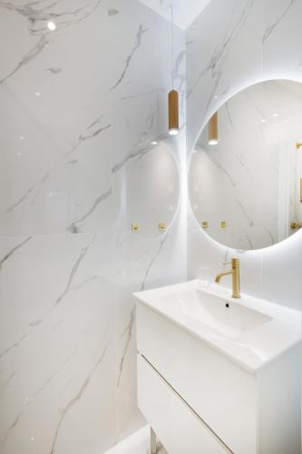 une salle de bain blanche avec un lavabo et un miroir dans l'établissement Casa Josa - Rue d'Antibes, à Cannes