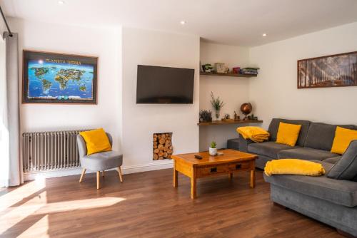 a living room with two couches and a tv at Tu Casa Brighton , A Beautiful & Peaceful 4 bedroom House with garden, BBq area , EV & Parking in Brighton & Hove