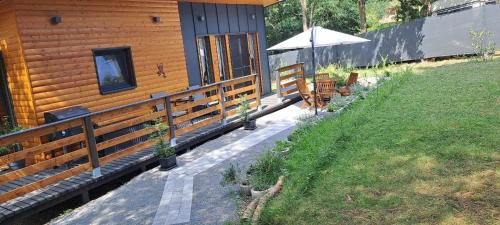 a wooden cabin with a table and an umbrella at Szalonka Vendégház Kemence in Kemence