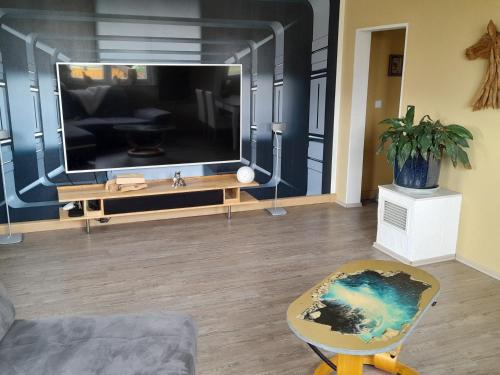 un soggiorno con una grande TV a schermo piatto di Ferienwohnung Rhönblick a Bad Königshofen im Grabfeld