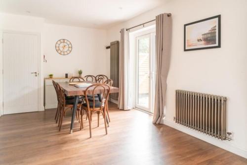 a dining room with a wooden table and chairs at Tu Casa Brighton , A Beautiful & Peaceful 4 bedroom House with garden, BBq area , EV & Parking in Brighton & Hove