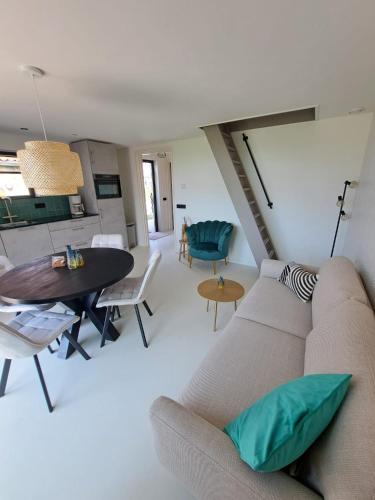 a living room with a couch and a table at Muziekskuur in Hollum