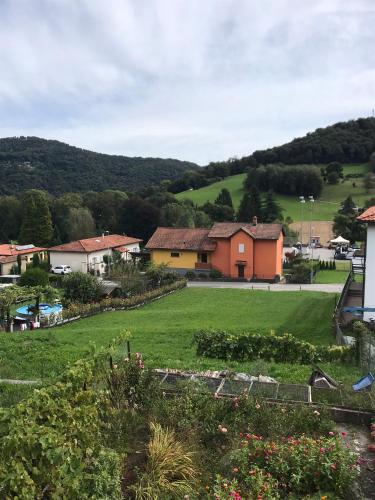 a small village with a green field and houses at Casa Galett in Novaggio