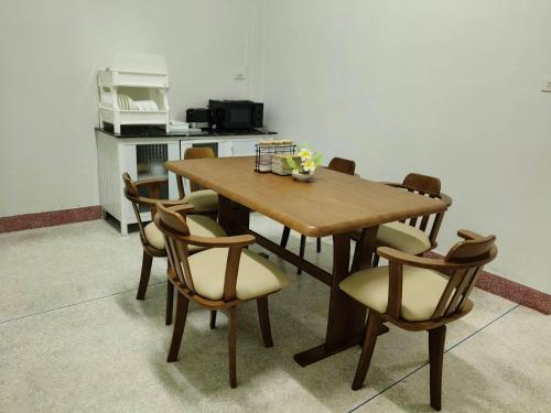 a wooden table and chairs in a kitchen at Nathamon House Hatyai in Hat Yai