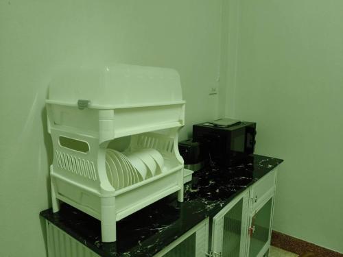 a white kitchen with a counter with a microwave at Nathamon House Hatyai in Hat Yai