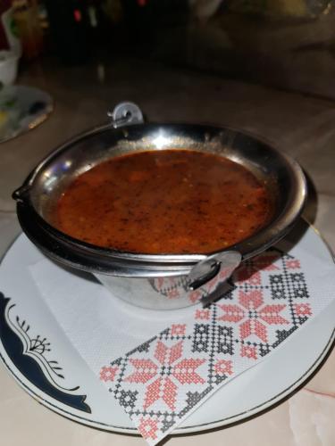 a pot of food on a plate on a table at Complex Turistic Caprioara in Baia Mare