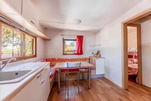 a kitchen and dining room with a table and chairs at Camping Bungalow Lido in Capoliveri