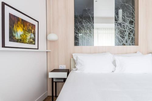 a bedroom with a bed and a picture on the wall at Eau Thermale Avène l'hôtel in Avène