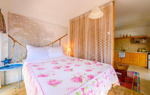 a bedroom with a large bed with pink flowers on it at צימר אדיגה in Kafr Kamā