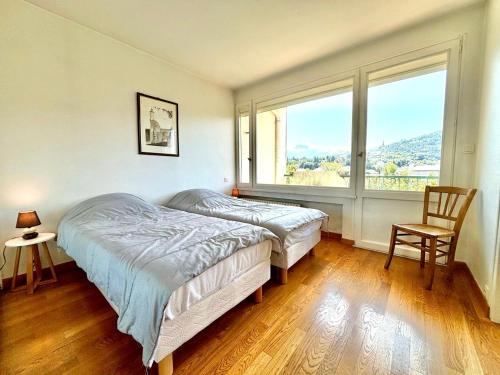 une chambre avec un lit et une grande fenêtre dans l'établissement Appartement à Annecy avec balcon, garage, proche centre historique et lac - FR-1-432-49, à Annecy