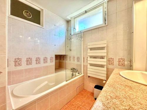 une salle de bain avec une baignoire et un lavabo dans l'établissement Appartement à Annecy avec balcon, garage, proche centre historique et lac - FR-1-432-49, à Annecy
