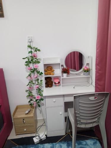 a desk with a tree and a mirror and a chair at Kijal Homestay in Kemasik