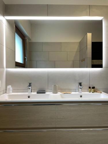 a bathroom with two sinks and a large mirror at Rustic Apartment -100mt from BerninaExpress in Tirano