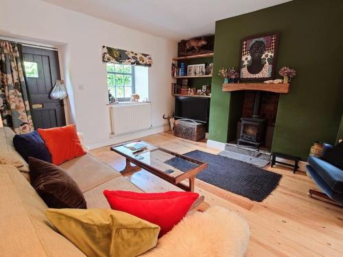 a living room with a couch and a fireplace at Cosy Welsh Town Cottage in Brecon