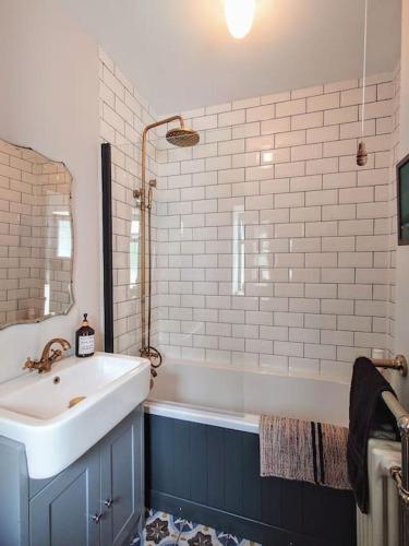 a bathroom with a sink and a bath tub at Cosy Welsh Town Cottage in Brecon