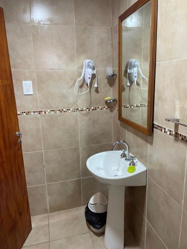 a bathroom with a sink and a mirror at Cabañas KAPO TEAM in Villa Amancay