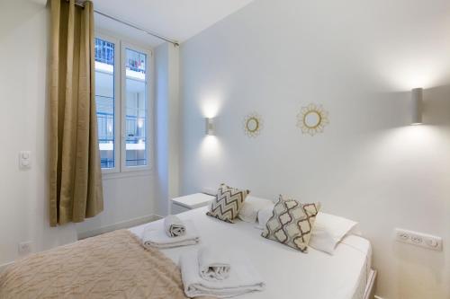 une chambre blanche avec un lit et une fenêtre dans l'établissement Casa Josa - Suquet, à Cannes