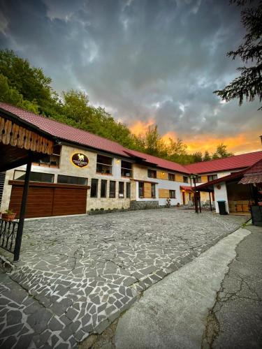 a building with a stone courtyard in front of it at Complex Turistic Caprioara in Baia Mare