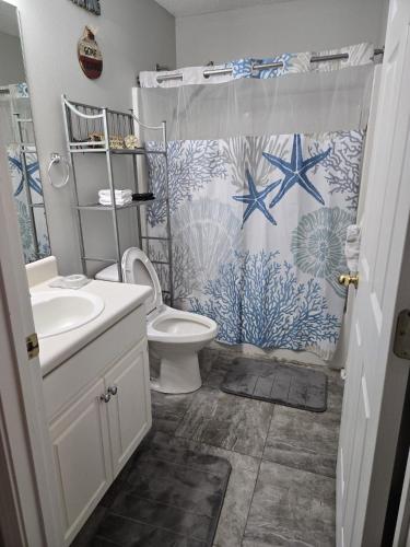 a bathroom with a toilet and a shower curtain at The Crestview Beach House in Crestview