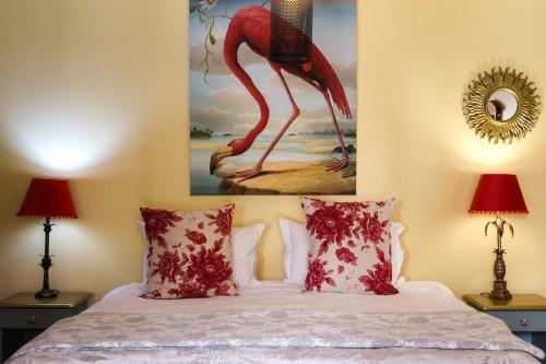 a bedroom with a bed with a painting of a flamingo at The Gate Guesthouse in Clarens