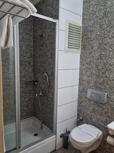 a bathroom with a shower and a toilet at Çilek Marina Otel in Çeşme