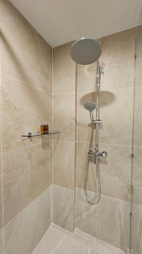 a bathroom with a shower with a glass door at Betworld Casino & Hotel in Krong Poi Pet