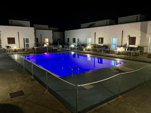 a large swimming pool with blue water at night at Licinio's Apartments - Casa Lavanda in Pantelleria