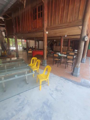 a patio with yellow chairs and tables in a building at Time Travel - Ha Giang Loop Tour in Ha Giang
