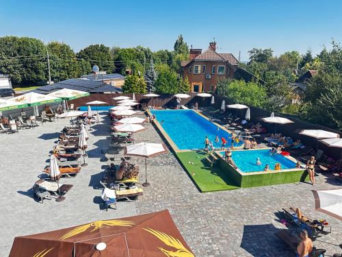 an overhead view of a swimming pool with people sitting around it at СИТИЙ КОВБОЙ in Leznevo