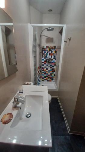 une salle de bain avec un lavabo blanc et des toilettes dans l'établissement Joli Studio vue mer 200 m de la plage, à Pléneuf-Val-André