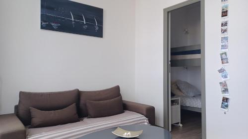 un salon avec un canapé et un miroir dans l'établissement Joli Studio vue mer 200 m de la plage, à Pléneuf-Val-André