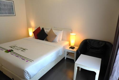 a hotel room with a bed and a chair at TME Retreats Dhigurah in Dhigurah