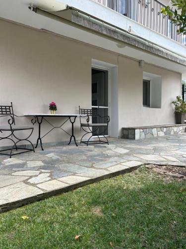 a patio with a table and chairs next to a building at Blue Pines in Péfka