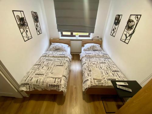 two beds in a small room with a window at Miejska Stodoła in Biała Podlaska